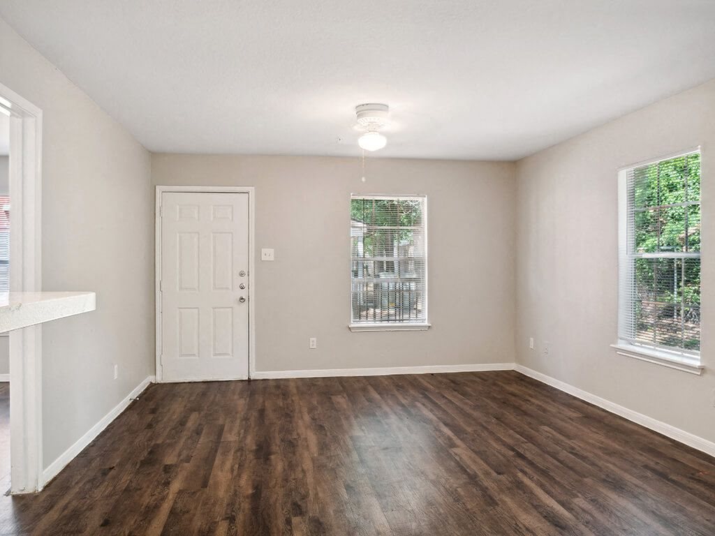 Living room with wood flooring at Park Village Apartments in Conroe TX